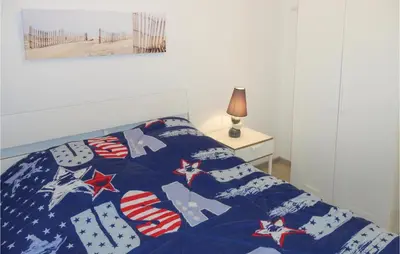 a bed with an american flag quilt on it at Nice Apartment In Gruissan With Kitchen in Gruissan