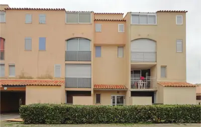 a building with a dog on a balcony at Nice Apartment In Gruissan With Kitchen in Gruissan