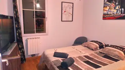 a bedroom with a bed with a chair and a window at Chambre avec petit déjeuner in Carcassonne