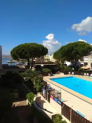 a view of a swimming pool with trees and buildings at Grand studio la Presqu'île 2 in Gruissan