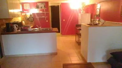a kitchen with red walls and a white counter in a room at Le Refuge in Puivert