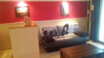 a living room with a couch and a red wall at Le Refuge in Puivert