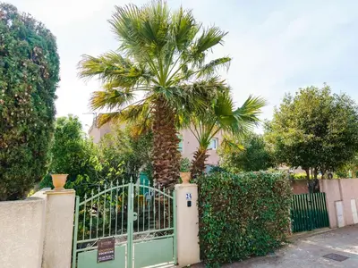 a palm tree behind a gate with a fence at Pavillon 3 pièces avec Terrasse à Gruissan - 4 Couchages, Animaux Admis, Parking Privé - FR-1-409-31 in Gruissan