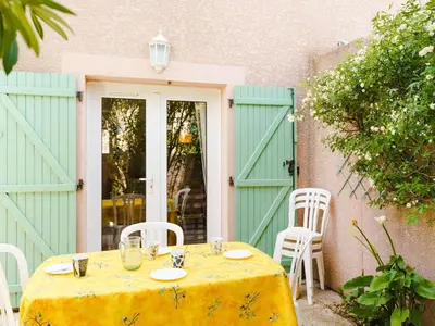 a table with a yellow table cloth sitting in front of a door at Pavillon 3 pièces avec Terrasse à Gruissan - 4 Couchages, Animaux Admis, Parking Privé - FR-1-409-31 in Gruissan