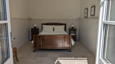 a bedroom with a bed with two night stands and two lamps at Gîte Wistéria in Mazamet