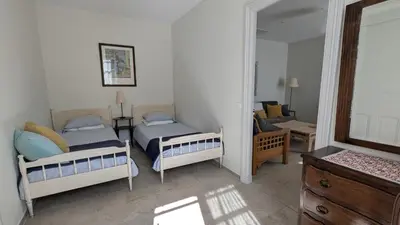 a bedroom with two beds and a mirror at Gîte Wistéria in Mazamet