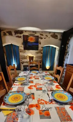 a table with plates and wine glasses on it at Gite Charlrose at La Platriere in Cazedarnes
