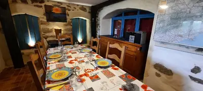 a table with plates on it in a dining room at Gite Charlrose at La Platriere in Cazedarnes