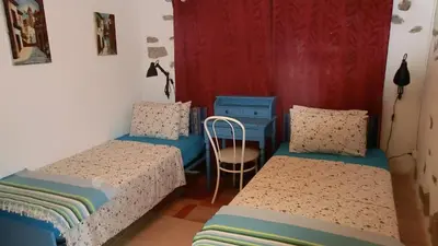 a bedroom with two beds and a table and a chair at Gite Charlrose at La Platriere in Cazedarnes