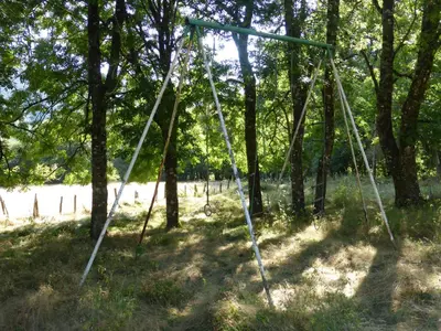 a swing set in the shade of trees at La Bouriotte, chambre d'hôtes Sycomore, in Labastide-Rouairoux