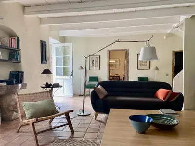 a living room with a black couch and a chair at La Maison Du Village in Val-de-Dagne