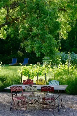 three chairs and a table in a park at La Maison Du Village in Val-de-Dagne