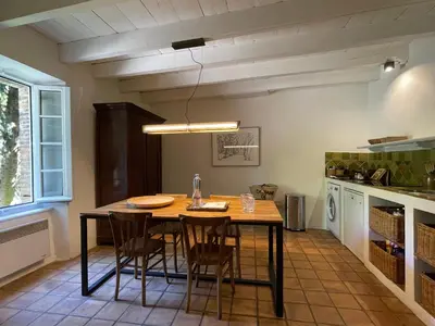 a kitchen with a wooden table and chairs at La Maison Du Village in Val-de-Dagne