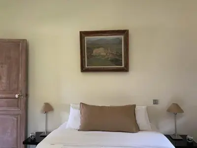 a bedroom with a bed and a painting on the wall at Le Pavillon Du Regisseur in Val-de-Dagne