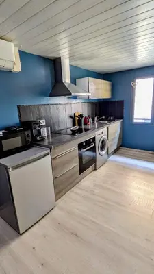 a kitchen with a stove and a washing machine at Appartement Lila in Carcassonne