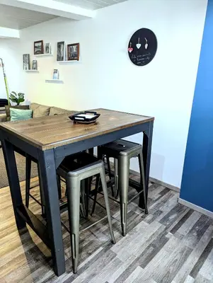a dining room table with two stools around it at Appartement Lila in Carcassonne