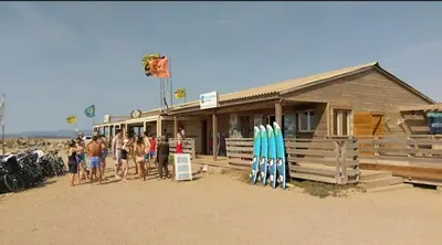 a group of people standing in front of a building with surfboards at Duplex Climatisé 65m2 refait à neuf in Gruissan
