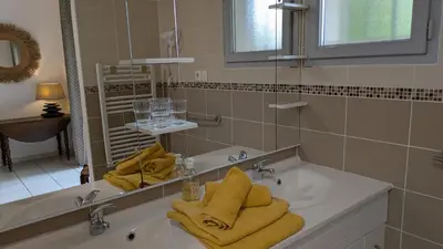 a bathroom with a sink with towels and a mirror at chambres d'hôtes du moulin in Peyriac-de-Mer