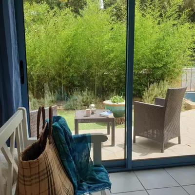 a patio with a table and chairs and a sliding glass door at chambres d'hôtes du moulin in Peyriac-de-Mer