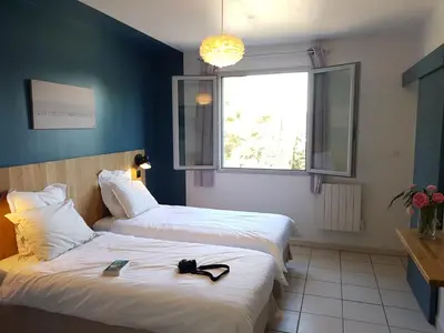 a hotel room with two beds and a window at chambres d'hôtes du moulin in Peyriac-de-Mer