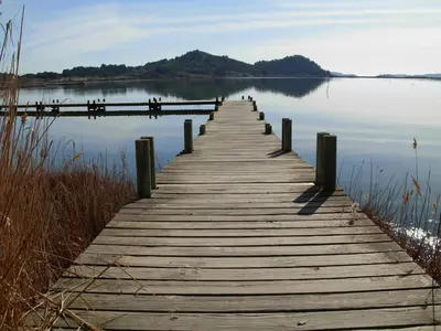 a wooden bridge over a body of water at chambres d'hôtes du moulin in Peyriac-de-Mer