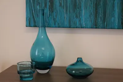 a green vase and a glass on a table at Gîte tout Confort au Coeur du Village Verniolle in Verniolle