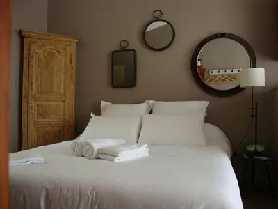 a bedroom with a white bed with towels on it at Gîte Les Roseaux Spa extérieur privatif inclus in Moussan