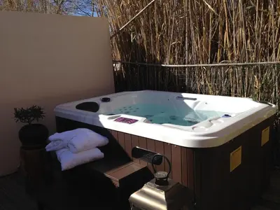 a jacuzzi tub with towels sitting in it at Gîte Les Roseaux Spa extérieur privatif inclus in Moussan