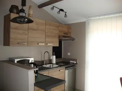 a kitchen with a sink and a stove top oven at Gîte Les Roseaux Spa extérieur privatif inclus in Moussan