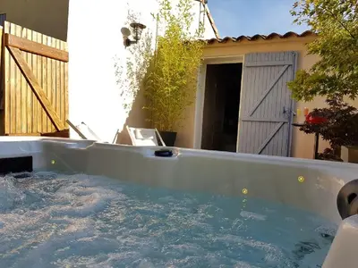 a hot tub in the backyard of a house at Gîte Les Roseaux Spa extérieur privatif inclus in Moussan