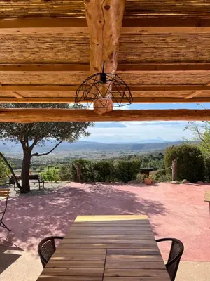a wooden pergola with a picnic table and chairs at Chambres d'hôtes Gîte Saint Roch in Tuchan