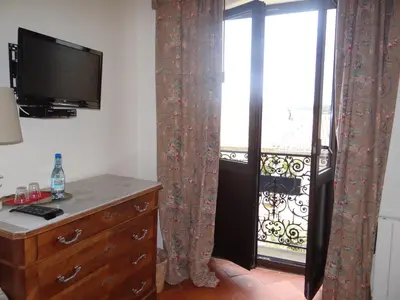 a room with a dresser and a television and a window at La Grande Maison in Cambieure