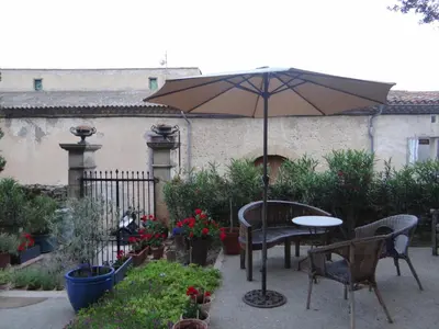 a patio with an umbrella and a table and chairs at La Grande Maison in Cambieure