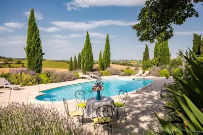 a pool with chairs and a table in a garden at La Segonne in Montréal