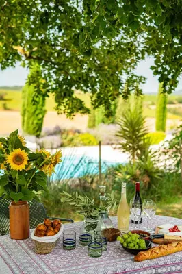 a picnic table with food and wine bottles and flowers at La Segonne in Montréal
