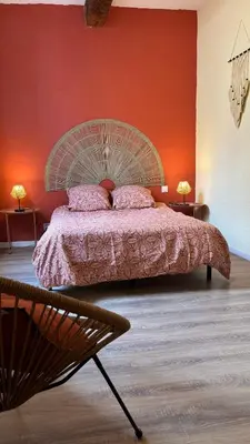 a bedroom with a large bed with a red wall at Just Like home in Carcassonne in Carcassonne