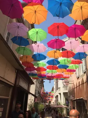 a bunch of colorful umbrellas hanging from a building at Just Like home in Carcassonne in Carcassonne