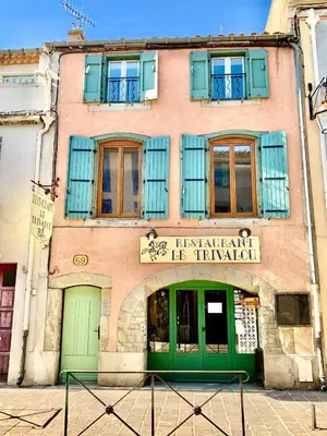 a building with green doors and windows on a street at Just Like home in Carcassonne in Carcassonne