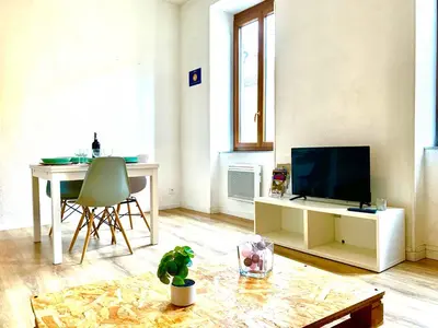 a living room with a table and a television at Just Like home in Carcassonne in Carcassonne