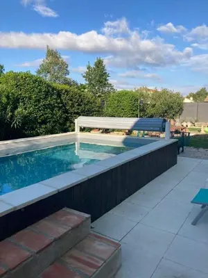 a swimming pool with a bench next to a fence at Gîte Chez Les Brocs in Canet d'Aude