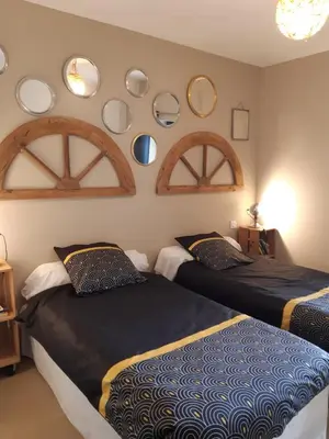 two beds in a room with mirrors on the wall at Gîte Chez Les Brocs in Canet d'Aude