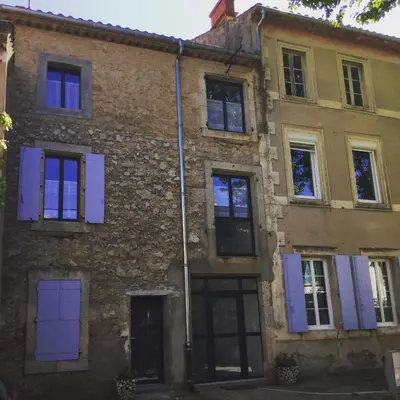 an old brick building with blue doors and windows at Gîte Chez Les Brocs in Canet d'Aude