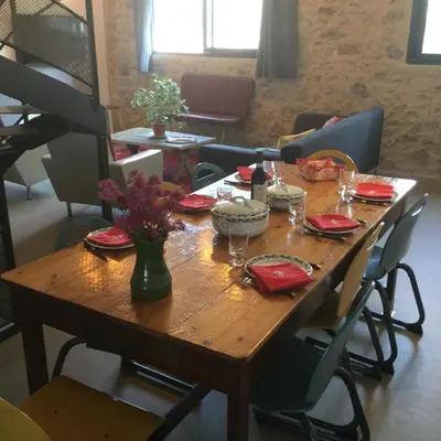 a wooden table with plates and wine glasses on it at Gîte Chez Les Brocs in Canet d'Aude
