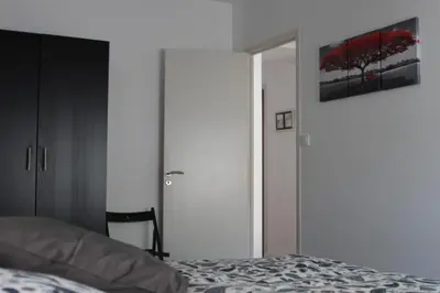 a bedroom with a bed and a sliding glass door at Gîte les 3 tours 1e étage in Carcassonne