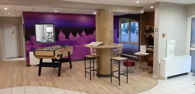 a room with a ping pong table and a purple wall at ibis Carcassonne Centre - La Cité in Carcassonne