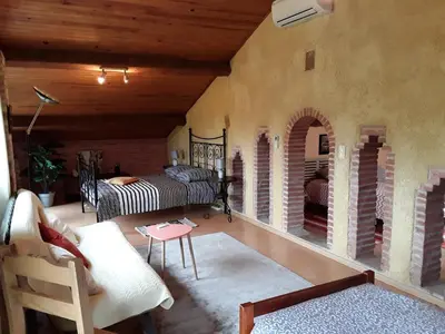 a living room with a couch and a bed and a table at LA LOUISIANE 31 in Villefranche-de-Lauragais