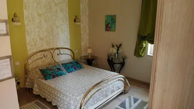 a bedroom with a bed and two end tables at LA LOUISIANE 31 in Villefranche-de-Lauragais