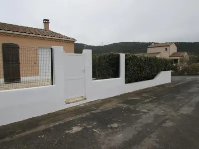 a white fence with a gate in a driveway at Maison Minervois in Agel