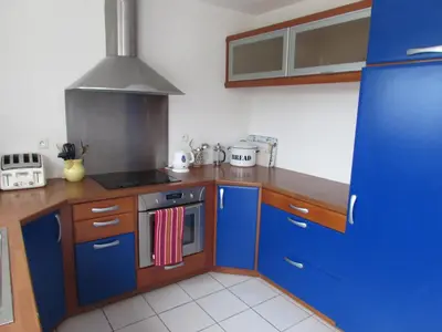 a kitchen with blue cabinets and a stove top oven at Maison Minervois in Agel