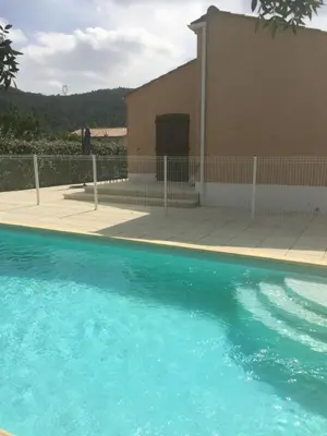a pool of blue water in front of a building at Maison Minervois in Agel